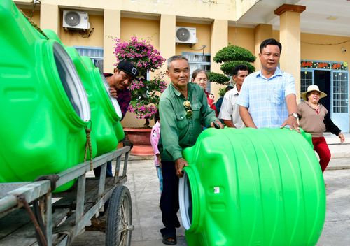 Phó Chủ tịch UBND xã Đông Thái Nguyễn Văn Phương hỗ trợ người dân vận chuyển bồn chứa nước về nhà.