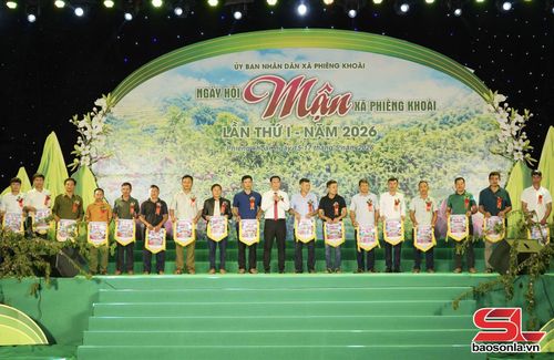 Lãnh đạo xã Phiêng Khoài trao cờ lưu niệm cho đại diện các bản, trường học tham gia Ngày hội.