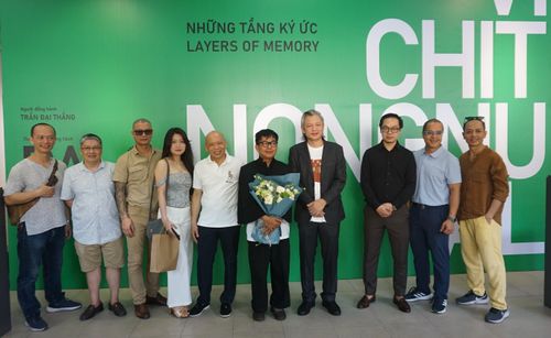 Họa sĩ Vichit Nongnual nhận hoa chúc mừng từ các họa sĩ Việt Nam nhân triển lãm "Những tầng ký ức - Layers of Memory"