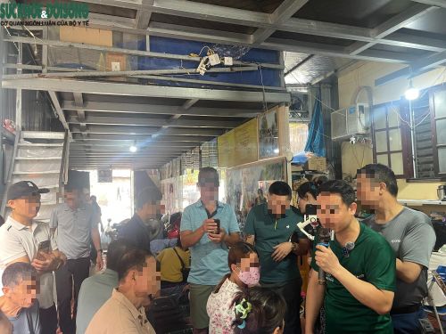 Ông Tuân (áo xanh) cầm míc đang tư vấn cho nhiều người.