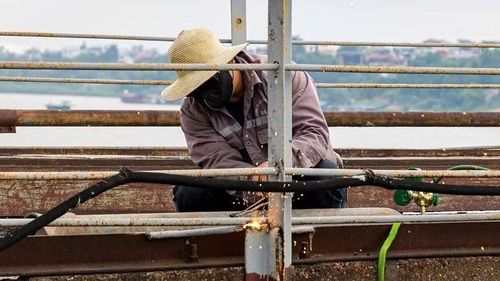 Công nhân hàn, sửa chữa, thay thế lan can hư hỏng trên cầu.