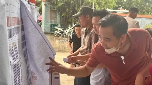 Người dân hào hứng tìm lô đất trong khu tái định cư mà mình vừa bốc thăm trúng.