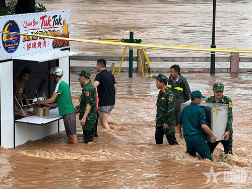  Lực lượng Bộ đội Biên phòng hỗ trợ hộ dân kinh doanh tại khu vực chợ đêm di chuyển tài sản đến nơi an toàn.