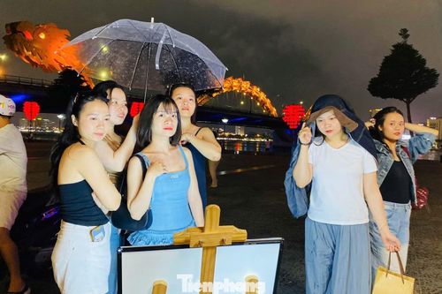Trời đổ mưa, nhóm bạn trẻ vẫn cố nán lại để được trải nghiệm chụp ảnh với photobooth đường phố.