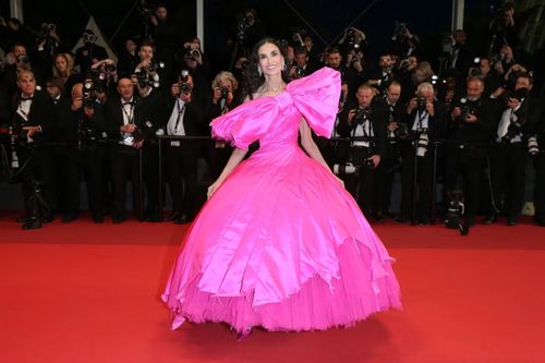 Sau một ngày tạm vắng mặt, Demi Moore trở lại thảm đỏ Cannes và dễ dàng trở thành tâm điểm. Bà mặc chiếc váy hồng tươi bồng bềnh kiểu công chúa, với điểm nhấn là chiếc nơ khổng lồ ở trước ngực. Ngôi sao Hollywood phối hợp trang phục với đôi giày cao gót màu hồng có nơ và bông tai kim cương bản lớn. Ảnh: Getty Images.