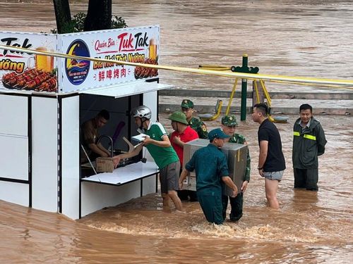 Cán bộ, chiến sĩ Đồn Biên phòng Cửa khẩu quốc tế Móng Cái phối hợp cùng lực lượng chức năng hỗ trợ người dân di dời tài sản, ứng phó mưa lũ.