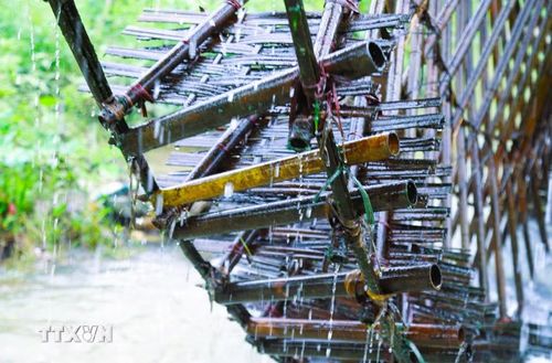Trên vành bánh quay của cọn nước được gắn hàng trăm ống nứa để có hướng hơi nghiêng để đựng nước từ mặt suối rồi dâng lên cao theo chiều quay của bánh xe cọn nước. (Ảnh: Xuân Tiến/TTXVN)
