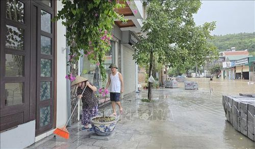 Người dân liên tục quét để ngăn nước tràn vào nhà.