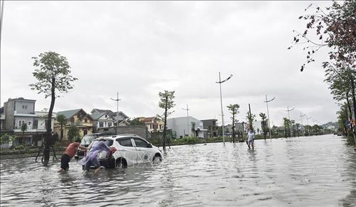 Có người phải đẩy xe ô tô do chết máy giữa đường vì ngập nước.