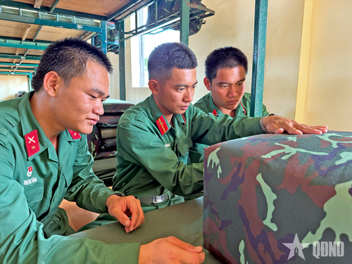  Chiến sĩ Triệu Văn Đức và chiến sĩ Triệu Văn Thắng cùng nhau học gấp chăn. 