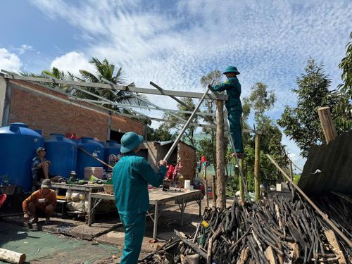 Lực lượng chức năng xã Vĩnh Châu hỗ trợ người dân sửa chữa nhà 