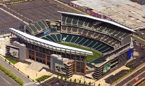 Lincoln Financial Field là tác phẩm bắt tay giữa NBBJ và Agoos Lovera Architects. Lấy cảm hứng từ chính tên gọi của đội bóng chủ quản, hệ thống mái che phía Đông và phía Tây được tạo hình mềm mại như một đôi cánh đang dang rộng. Trải nghiệm thị giác này được hoàn thiện nhờ góc ban công "Eagle's Nest" ở phía Bắc sân, cùng biểu tượng đội bóng được định hình nổi bật bằng những hàng ghế xanh đậm tại khu vực khán đài trên cùng. (Ảnh: Fine Art America)