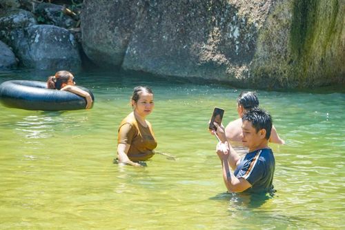 Không chỉ tắm mát, nhiều du khách còn tranh thủ ghi lại những khoảnh khắc giữa khung cảnh núi rừng nguyên sơ. Những phiến đá lớn ven suối, màn nước trắng xóa cùng màu xanh của đại ngàn trở thành phông nền tự nhiên thu hút du khách chụp ảnh, check-in.