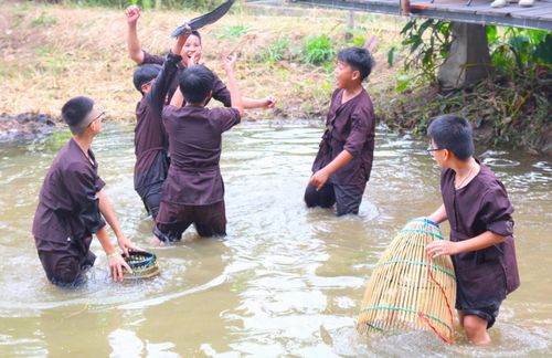 Trẻ em tham gia phần thi bắt cá dưới đồng. Ảnh: NGỌC QUỐC