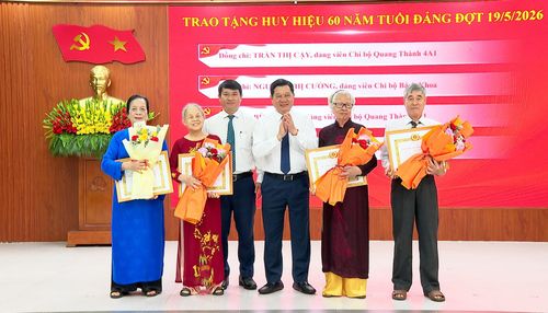 Phó Chủ tịch Thường trực HĐND thành phố Trần Phước Sơn tặng hoa chúc mừng các đảng viên nhận Huy hiệu Đảng. Ảnh: VŨ QUÂN