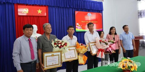 Lãnh đạo Đảng ủy xã Tân Phú Trung chụp ảnh cùng các đảng viên nhận Huy hiệu 30 năm và 40 năm tuổi Đảng đợt 19-5-2026.