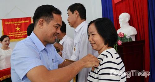 Đồng chí Lê Bình An, Phó Bí thư Đảng ủy, Chủ tịch UBND xã Tân Phú Trung trao tặng Huy hiệu Đảng cho đảng viên tại buổi lễ.