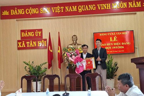 Đồng chí Hồ Quốc Trung, Bí thư Đảng ủy, Chủ tịch HĐND xã Tân Hội trao Huy hiệu Đảng cho đồng chí Hoàng Doãn Hiền