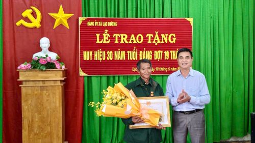 Đồng chí Đỗ Khắc Lợi, Phó Bí thư Thường trực Đảng ủy xã Lạc Dương trao tặng Huy hiệu 30 năm tuổi Đảng cho đảng viên Kơ Đơng Ha Dương