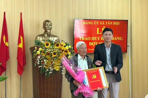 Đồng chí Hồ Quốc Trung, Bí thư Đảng ủy, Chủ tịch HĐND xã Tân Hội trao Huy hiệu Đảng cho đồng chí Chu Văn Dụng