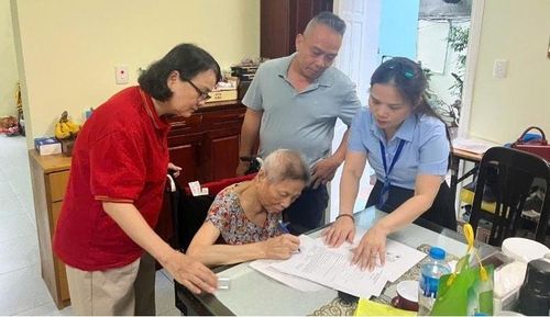 Tổ xung kích hỗ trợ chứng thực chữ ký tại nhà cho bà Đỗ Thị Nhu tại số 18 Nguyễn Phong Sắc, phường Cầu Giấy. Ảnh: Thúy Hoa