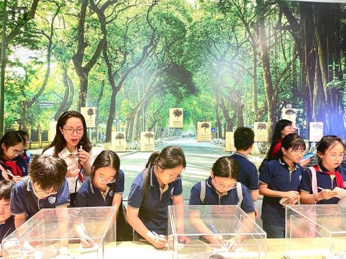 Các bạn học sinh ghi chép lại thông tin khi đến tham quan Bảo tàng Hà Nội. Ảnh: BTNH.