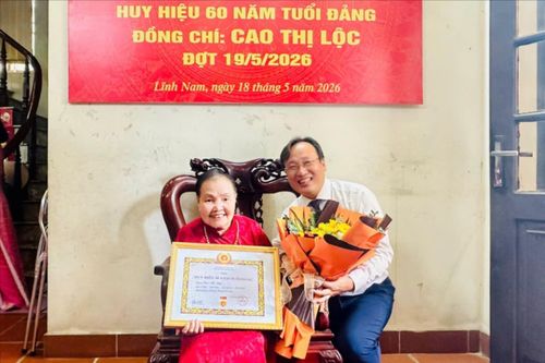 Bí thư Đảng ủy phường Lĩnh Nam Đỗ Thanh Tùng trao Huy hiệu Đảng cho đồng chí Cao Thị Lộc tại nhà riêng. Ảnh: PV
