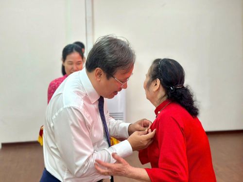 Bí thư Đảng ủy phường Lĩnh Nam Đỗ Thanh Tùng trao Huy hiệu Đảng tặng các đảng viên. Ảnh: PV