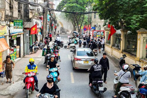 Dòng phương tiện di chuyển qua khu vực thi công giữa mạng lưới ngõ nhỏ đông đúc.