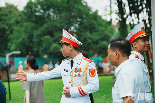 Cán bộ, chiến sĩ Bộ tư lệnh Lăng Chủ tịch Hồ Chí Minh hướng dẫn nhân dân nhận bánh mì và nước uống miễn phí phục vụ người vào Lăng viếng Bác.