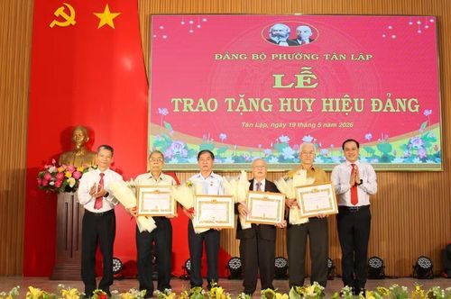 Lãnh đạo Đảng ủy phường Tân Lập trao Huy hiệu 55 năm tuổi Đảng cho các đảng viên. (Ảnh: Thành Tâm)