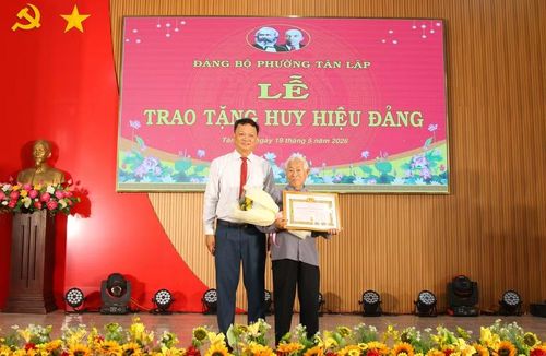 Ông Vũ Văn Hưng trao Huy hiệu 65 năm tuổi Đảng cho cụ Hồ Phi Thức. (Ảnh: Thành Tâm)