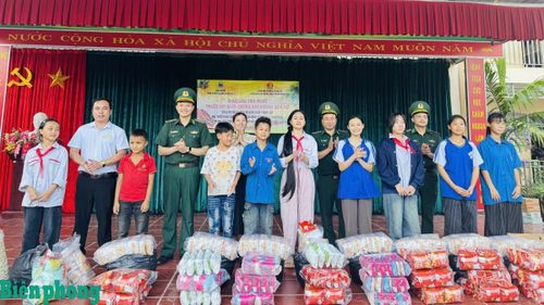 Cán bộ Đồn Biên phòng Nậm Nhừ trao quà tặng học sinh có hoàn cảnh đặc biệt khó khăn xã Nà Hỳ, tỉnh Điện Biên. Ảnh: Mùa Tùng