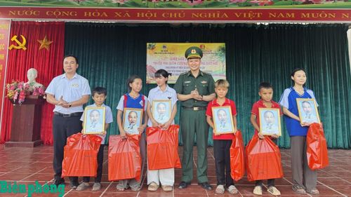 Cán bộ Đồn Biên phòng Nậm Nhừ trao ảnh Bác Hồ tặng học sinh xã Nà Hỳ, tỉnh Điện Biên. Ảnh: Mùa Tùng