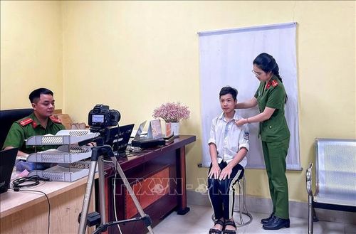 Nữ Công an phường Thuận Thành tận tình hướng dẫn học sinh đến làm CCCD.