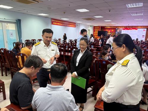 Cán bộ thuế trao đổi, làm rõ các câu hỏi của hộ kinh doanh liên quan đến phương thức quản lý thuế theo hình thức kê khai. Ảnh: Hứa Chung-TTXVN