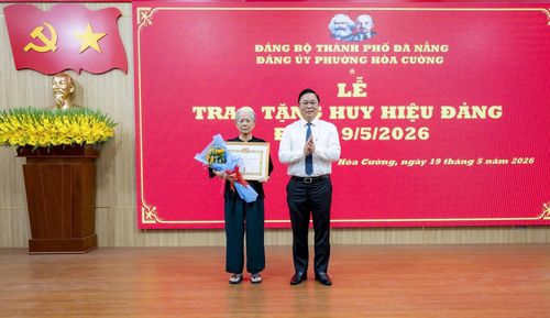 Chủ tịch Ủy ban MTTQ Việt Nam thành phố Lê Trí Thanh trao Huy hiệu Đảng cho đảng viên Nguyễn Thị Bảng (phường Hòa Cường). Ảnh: DIỄM HƯƠNG - TRẦN BỬU