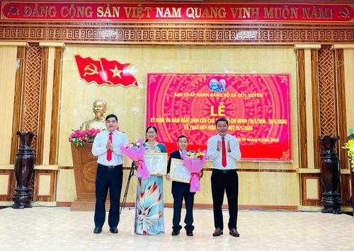 Đồng chí Nguyễn Mạnh Hà, Ủy viên Ban Thường vụ Thành ủy, Giám đốc Sở Dân tộc và Tôn giáo (bên trái) cùng lãnh đạo Đảng ủy xã Duy Xuyên (bên phải) trao tặng Huy hiệu Đảng cho đảng viên. Ảnh: T.S