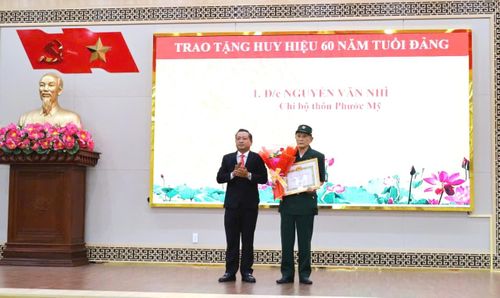 Lãnh đạo Đảng ủy xã Đại Lộc trao tặng Huy hiệu 60 năm tuổi Đảng cho đồng chí Nguyễn Văn Nhì. Ảnh: NGUYỄN TUYẾT