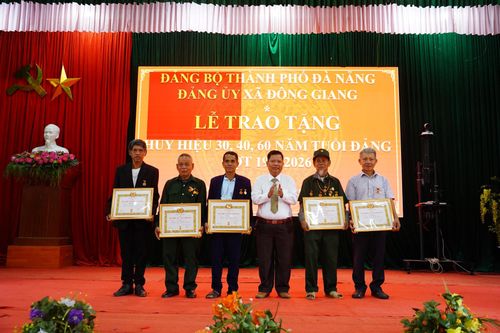 Các đảng viên nhận Huy hiệu Đảng. Ảnh: NGỌC VY
