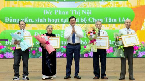 Phó Chủ tịch Thường trực HĐND thành phố Trần Phước Sơn (giữa) trao huy hiệu Đảng cho các đảng viên đủ tiêu chuẩn. Ảnh: QUANG THẮNG