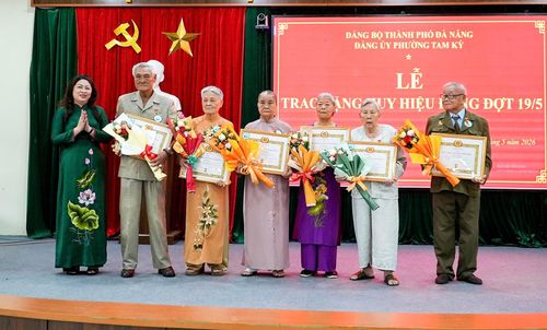 Bí thư Đảng ủy phường Tam Kỳ Nguyễn Thị Thu Lan (bên trái) trao Huy hiệu Đảng cho các đảng viên. Ảnh: HỒ QUÂN