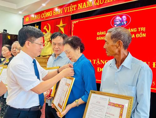Đại diện lãnh đạo Đảng ủy phường Ba Đồn trao Huy hiệu Đảng cho các đảng viên - Ảnh: H.L