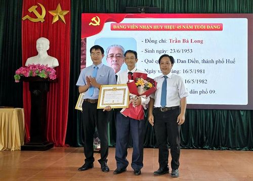 Lãnh đạo phường Kim Long trao Huy hiệu Đảng cho đảng viên 45 năm tuổi Đảng. Ảnh: Liên Minh