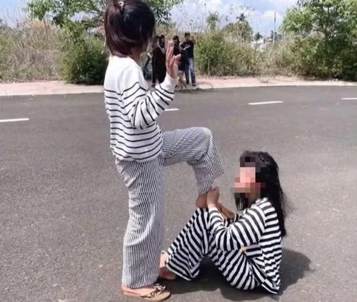 Hình ảnh em H.A.V. bị bạn đánh, quỳ dưới đất và liếm chân được nhóm học sinh ghi lại.