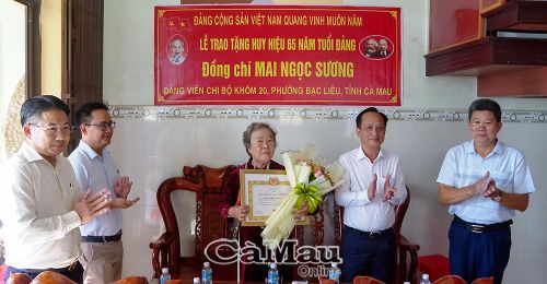  Chủ tịch HĐND tỉnh Phạm Văn Thiều trao Huy hiệu Đảng và tặng hoa chúc mừng đảng viên Mai Ngọc Sương.