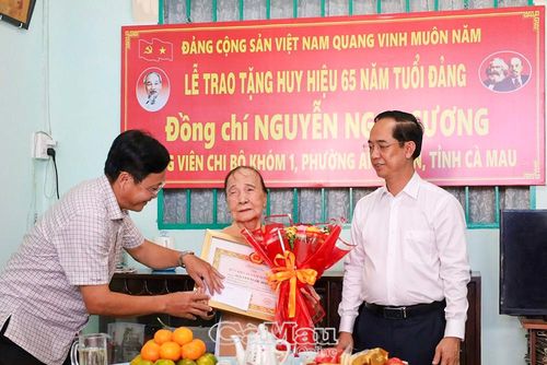  Đồng chí Hồ Văn Chung, Bí thư Đảng ủy phường An Xuyên (bìa trái), tặng quà, thăm hỏi sức khỏe đảng viên Nguyễn Ngọc Sương. 