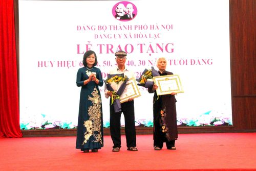 Phó Bí thư Thường trực Đảng ủy xã Hòa Lạc Nguyễn Thị Bích Ngọc trao Huy hiệu Đảng tặng các đảng viên cao tuổi. Ảnh: PV