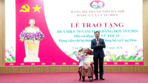 Đồng chí Đàm Văn Huân – Bí thư Đảng ủy, Chủ tịch HĐND xã trao Huy hiệu 70 năm tuổi Đảng tặng đảng viên Vũ Thị Ấu, sinh năm 1935, Chi bộ thôn Thần. Ảnh: Lê Quí