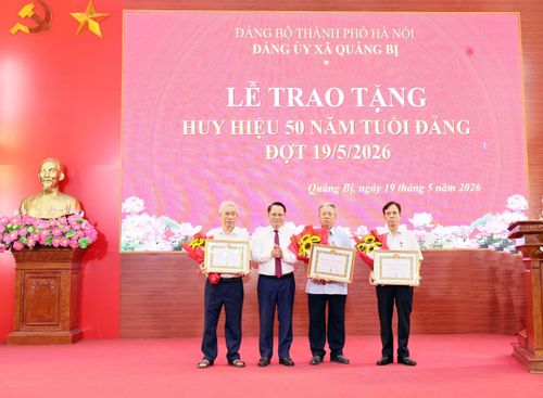Phó Bí thư Đảng ủy, Chủ tịch UBND xã Quảng Bị Bùi Mạnh Thắng trao Huy hiệu 50 năm tuổi Đảng cho các đồng chí đảng viên. Ảnh: Thanh Vân